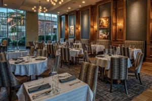 - une salle à manger avec des tables, des chaises et des fenêtres dans l'établissement Hilton Nashville Green Hills, à Nashville