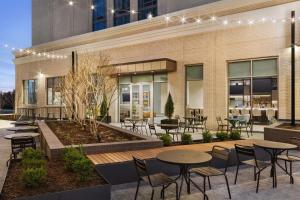a patio with tables and chairs in front of a building at Home2 Suites By Hilton Nashville West End Avenue in Nashville