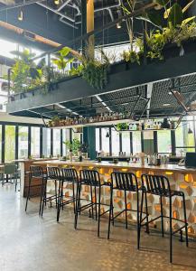 納許維爾的住宿－Placemakr Wedgewood-Houston，餐厅里的酒吧,有椅子和植物