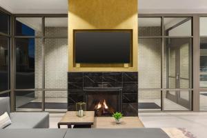 a living room with a fireplace and a tv on a wall at Hilton Garden Inn Nashville West End Avenue in Nashville