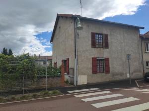 ein Gebäude mit roten Fenstern und einem Straßenlicht in der Unterkunft Maison de Campagne en centre Bourg in Renaison