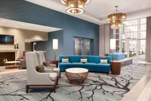 sala de estar con sofá azul y sillas en Homewood Suites By Hilton Charlotte Southpark, en Charlotte