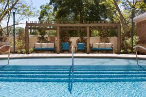 夏洛特的住宿－夏洛特南園希爾頓花園酒店，一个带椅子的游泳池和一个凉亭