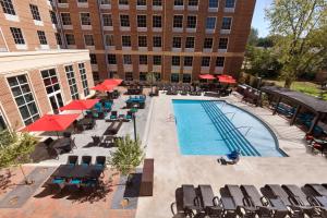 uma vista sobre uma piscina com cadeiras e um edifício em Hilton Garden Inn Charlotte Southpark em Charlotte
