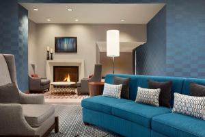 a living room with a blue couch and a fireplace at Homewood Suites By Hilton Charlotte Southpark in Charlotte