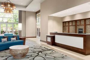 a lobby with a reception desk and a blue couch at Homewood Suites By Hilton Charlotte Southpark in Charlotte