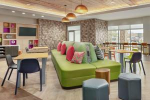 un soggiorno con divano verde e cuscini colorati di Home2 Suites By Hilton Colorado Springs South, Co a Colorado Springs