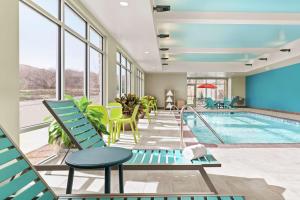 a pool in a hotel with chairs and a swimming pool at Home2 Suites By Hilton Colorado Springs South, Co in Colorado Springs