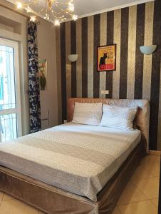een bed in een slaapkamer met een gestreepte muur bij Villa Aspalathos in Kaštela