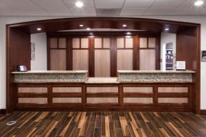 a lobby with a bar with wood paneling at Homewood Suites Denton in Denton +29 photos