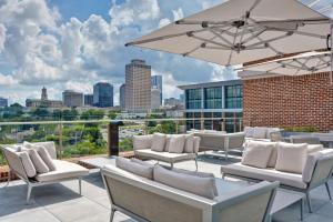 a patio with white chairs and an umbrella at Hampton Inn & Suites Nashville Downtown Capitol View, Tn in Nashville