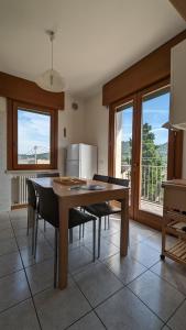 kuchnia ze stołem, krzesłami i lodówką w obiekcie Perla del Garda w mieście Garda
