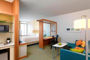Habitación de hotel con cama y sofá azul en SpringHill Suites by Marriott Houston I-45 North en Houston