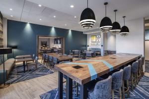 a dining room with a large wooden table and chairs at Hampton Inn Boston Woburn in Woburn