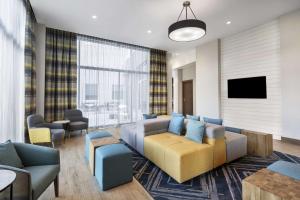 a living room with a couch and a tv at Hampton Inn Boston Woburn in Woburn