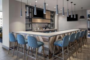 a kitchen with a bar with blue bar stools at Hampton Inn Boston Woburn in Woburn