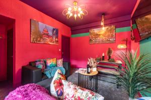 a living room with a couch and a pink wall at Hull 3 Bedrooms Garden Central House Sleeps 6 Hosanna MERCI Showy Cozy - Close to Princess Ave in Hull