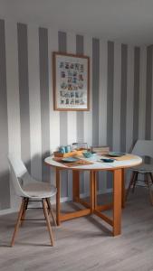 Gästezimmer Mitten in Angeln في Mittelangeln: طاولة خشبية وكرسي في غرفة مع جدار