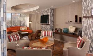 sala de estar con sillas, TV y mesa en Hampton Inn Orlando-International Airport en Orlando