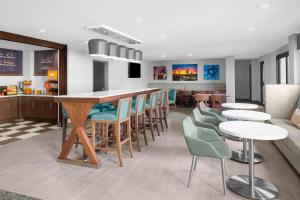 um restaurante com mesas e cadeiras e um bar em Hampton Inn Phoenix - Biltmore em Phoenix