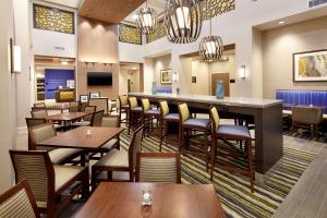 a restaurant with tables and chairs and a bar at Hampton Inn & Suites Pittsburgh Airport South/Settlers Ridge in Robinson Township