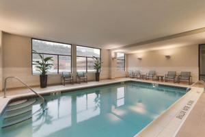 a pool in a hotel room with chairs and tables at Homewood Suites by Hilton Pittsburgh Downtown in Pittsburgh
