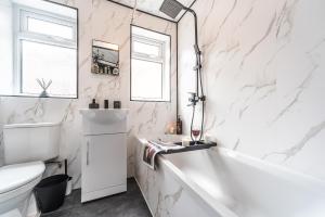 a white bathroom with a tub and a sink at Hull 3 Bedrooms Garden Central House Sleeps 6 Hosanna MERCI Showy Cozy - Close to Princess Ave in Hull +26 photos
