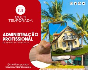 a hand holding a phone in front of a house at Pousada Quinta da Margem in Florianópolis
