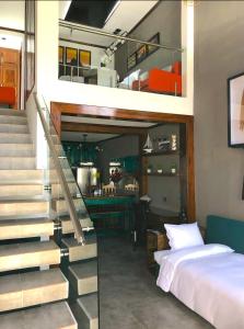 a bedroom with a bed and a staircase next to a bed at Brazilian Art & Free Parking - emitimos factura in Quetzaltenango