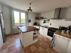 a kitchen with white cabinets and a tile floor at Villa La Libellule Grand Jardin et Parking Privé in Toulouse