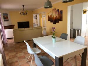 Villa La Libellule Grand Jardin et Parking Privé في تولوز: غرفة معيشة مع طاولة وكراسي بيضاء