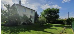 une maison blanche avec une cour avec de l'herbe et des arbres dans l'établissement Villa La Libellule Grand Jardin et Parking Privé, à Toulouse