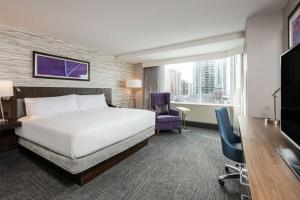 オタワにあるHomewood Suites By Hilton Ottawa Downtownのベッド、デスク、椅子が備わるホテルルームです。