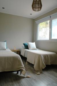 a bedroom with two beds and a window at COMPLEJO LA ISLA MAR CHIQUITA in Balneario Mar Chiquita