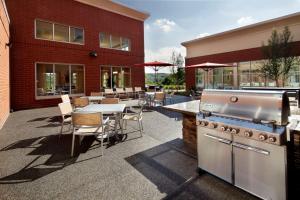 un patio esterno con barbecue, tavoli e sedie di Homewood Suites by Hilton Pittsburgh Airport/Robinson Mall Area a Moon Township