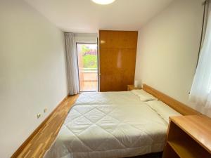a bedroom with a large bed and a window at Casa chalet jardín particular Ideal Grupos y familias in Barañáin