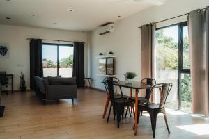 a living room with a table and chairs and a couch at Che Suites Tulum in Tulum