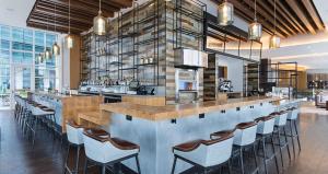 a bar in a restaurant with a bunch of chairs at Canopy By Hilton Washington DC The Wharf in Washington