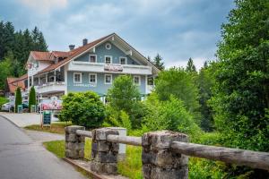 a blue house with a fence in front of it at Ski-Bike-Apartment Bayerwald in Lohberg