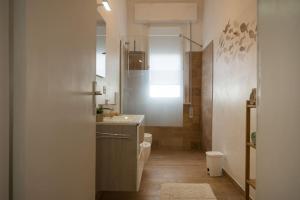 a bathroom with a sink and a toilet and a mirror at Perla Marina Appartamento in Rimini