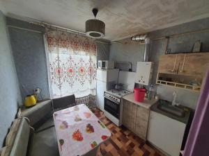 Una pequeña cocina con una mesa y un refrigerador. en Однокімнатні Апартаменти повністю, en Krivoy Rog