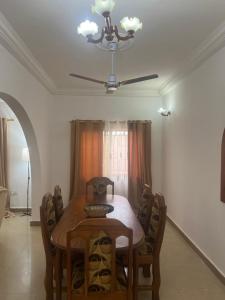 a dining room table with chairs and a ceiling fan at Lassida 1060 in Ker Bakary