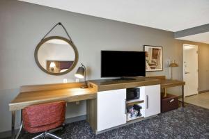 コロンバスにあるHampton Inn & Suites Columbus-Easton Areaのデスク、テレビ、鏡が備わる客室です。