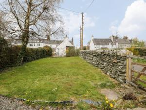 a yard with a stone wall and houses at 2 Fleet Street in Castle Douglas