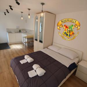 a bedroom with a large bed with a hogwarts crest on the wall at Self Contained, Garden Studio walking distance to Harry Potter Studio in Leavesden Green