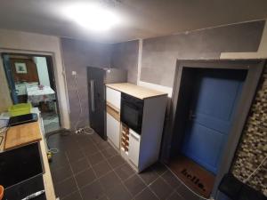 a kitchen being remodeled with a counter and a refrigerator at Pasja Grofica in Idrija