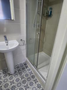 uma casa de banho com um chuveiro e um lavatório. em Dodi Apartment em Londres