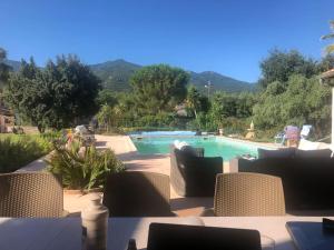 Blick auf einen Pool mit Stühlen und einem Tisch in der Unterkunft Luxury villa with amazing views in 3200m2 in Laroque-des-Albères
