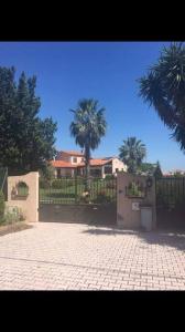 ein Haus mit einem Zaun und einer Palme in der Unterkunft Luxury villa with amazing views in 3200m2 in Laroque-des-Albères