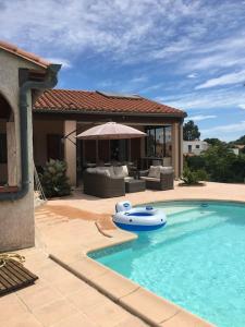 einen Pool mit einem aufblasbaren Boot in einem Haus in der Unterkunft Luxury villa with amazing views in 3200m2 in Laroque-des-Albères